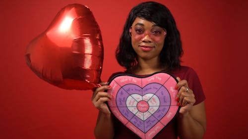 Woman in Red Shirt Smiling While Holding Valentine's Day Gifts