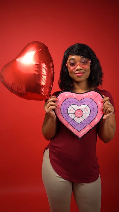 Woman in Red Shirt Smiling While Holding Valentine's Day Gifts