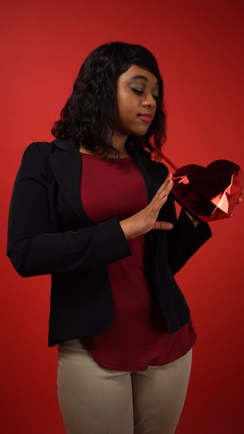 Woman Holding a Red Heart Shaped Object