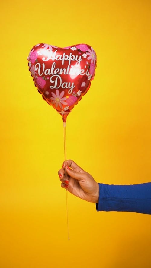 Person Holding a Heart Shaped Balloon