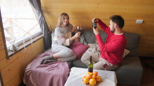 Man Taking of Pictures of a Woman Holding a Glass of Wine