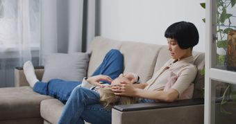 中年妈妈坐在沙发上，低头看手机，表情视频素材