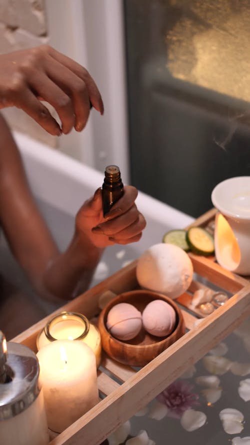 A Person Pouring Scented Oil on the Oil Burner