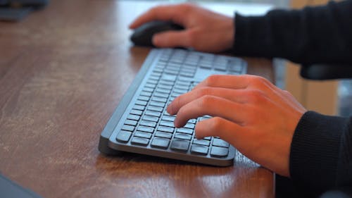 A Person Typing on a Wireless Keyboard