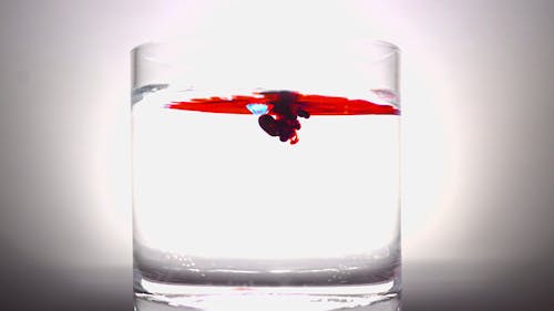 Red Paint Drop in Glass of Water