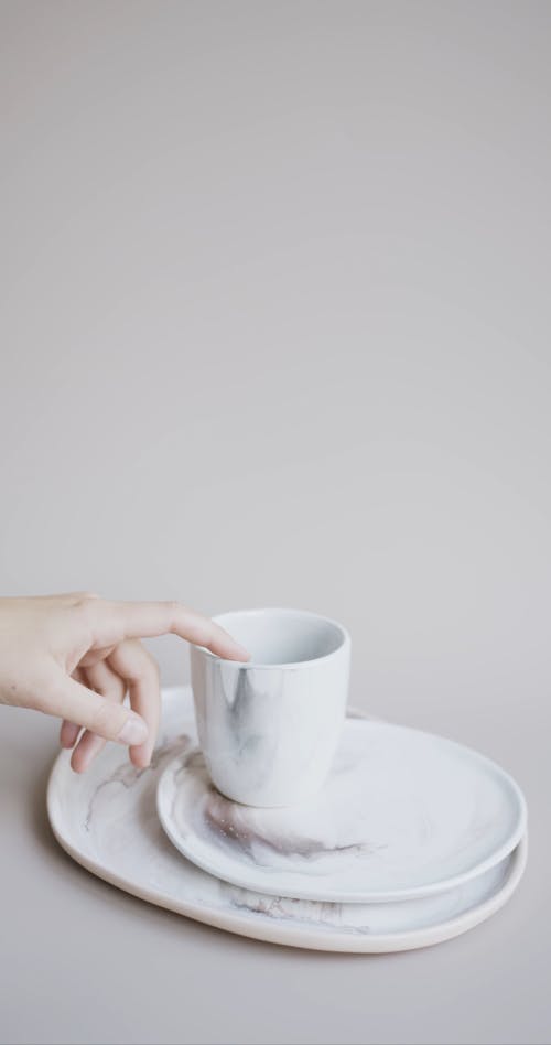 A Person Touching a Ceramic Cup