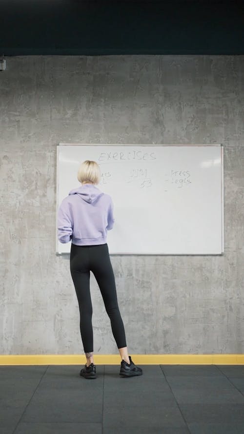 A Woman Writing Exercise Pilates On The Whiteboard