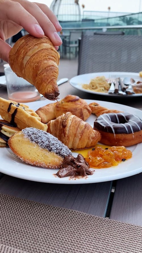 A Person Dipping a Croissant on Chocolate 