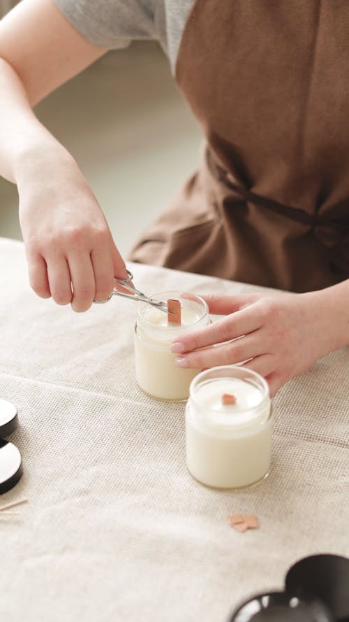 A Person Cutting a Candle Wick