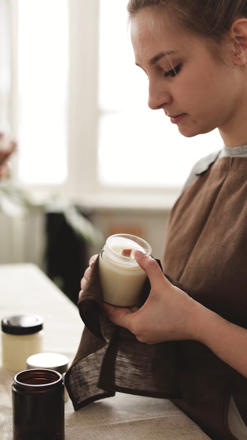 Woman Wiping Off Candle Jar