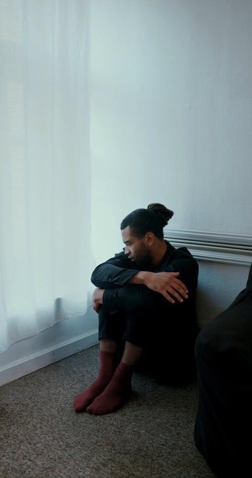 A Bearded Man Sitting on the Floor