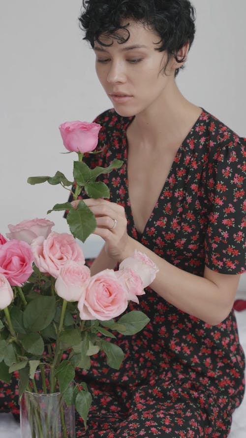 Woman Looking at Pink Rose