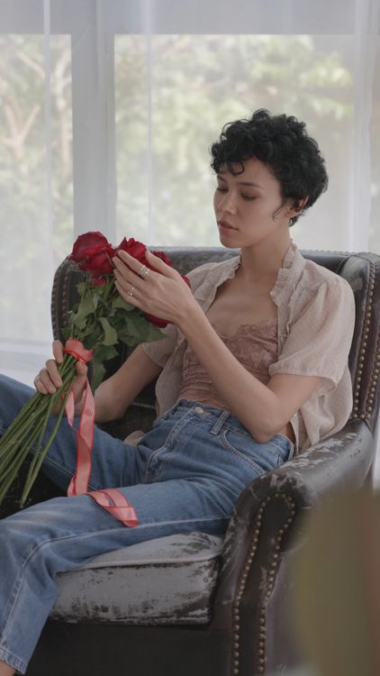A Woman Holding Red Roses while Sitting on the Chair Free Stock Video ...