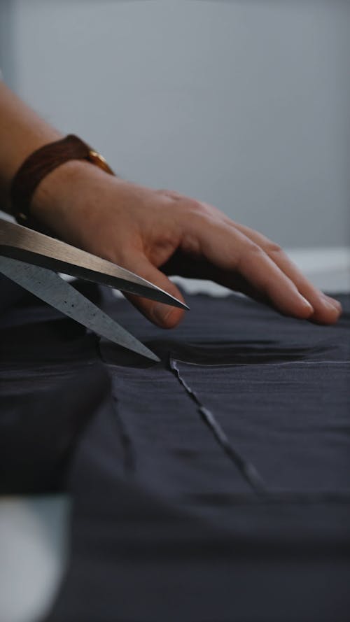 A Tailor Cutting a Fabric