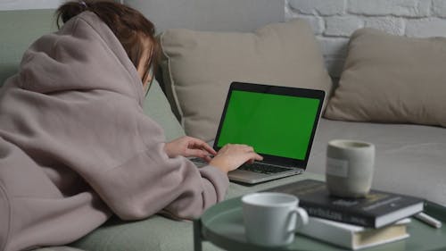 Woman in Brown Hoodie Using a Laptop