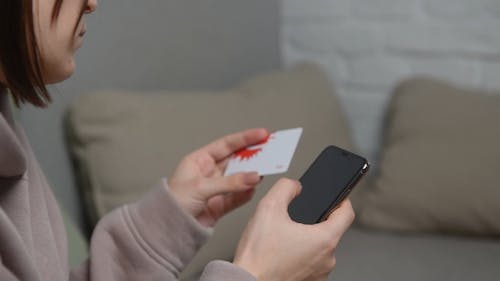 A Person Holding a Card While Texting