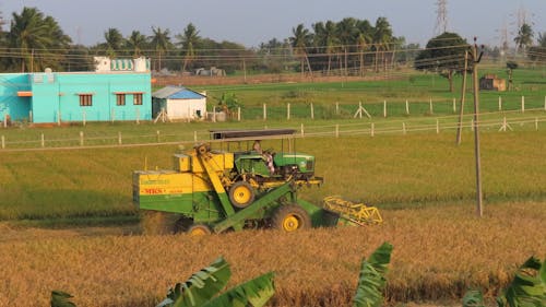 Farmer with Tractor Working in Field