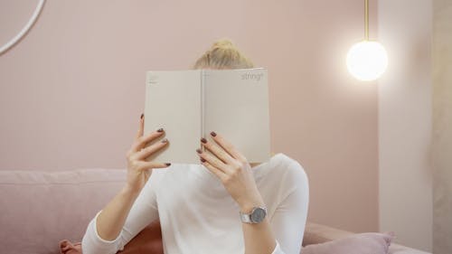 Woman Covering Her Face With a Book