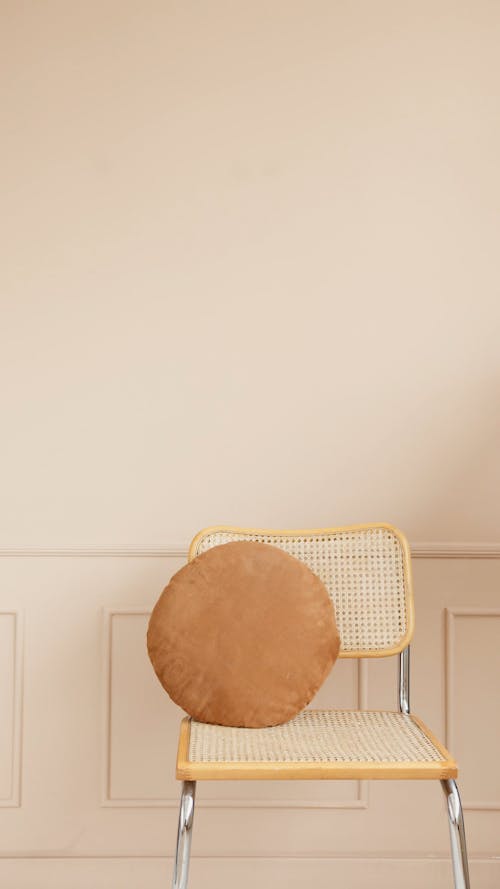 Person Placing Cushion On An Arm Chair