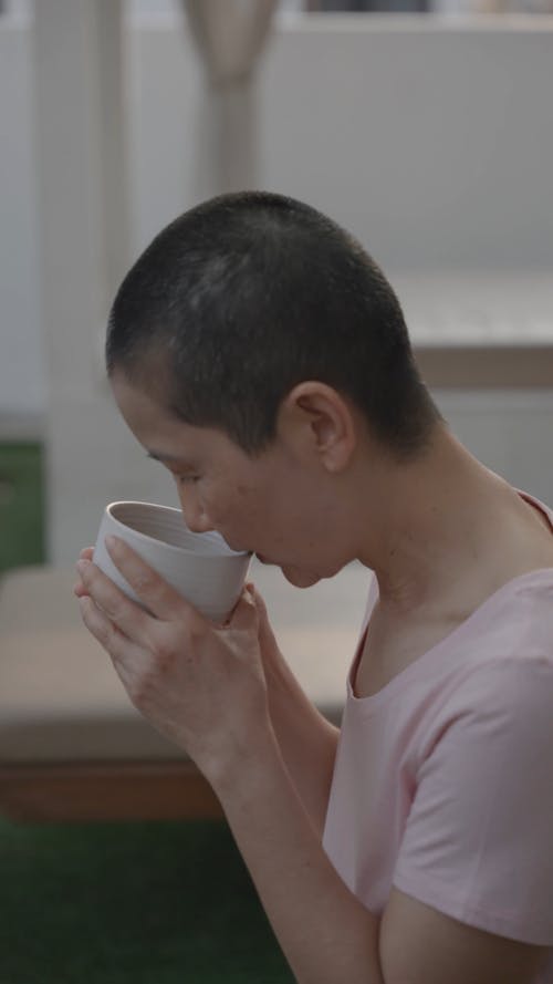 Woman Drinking in a White Cup