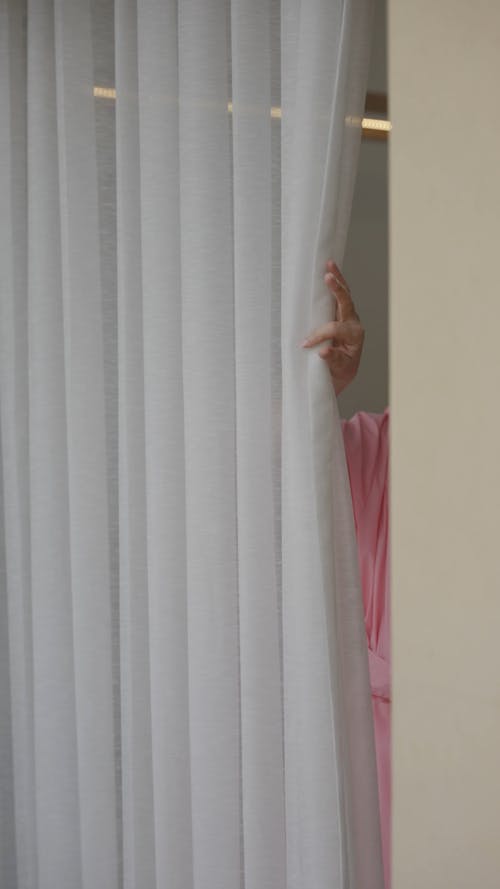 A Woman Opening Curtain