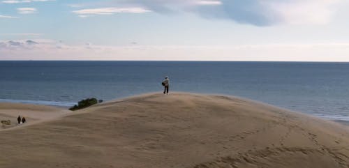 Person Walking on Top of Sand Dune