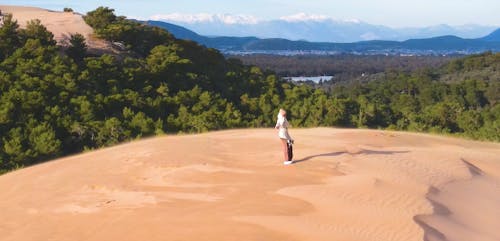 Person Standing on Top of Sand Dune