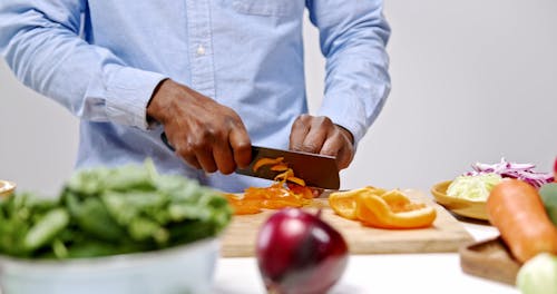 Men Chopping Vegetables In The Wooden Board