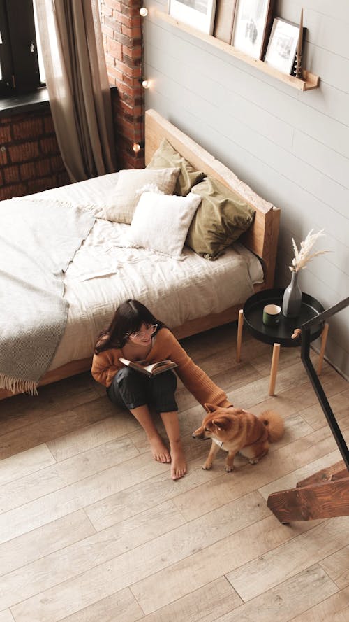 Woman Caressing Dog While Holds A Book