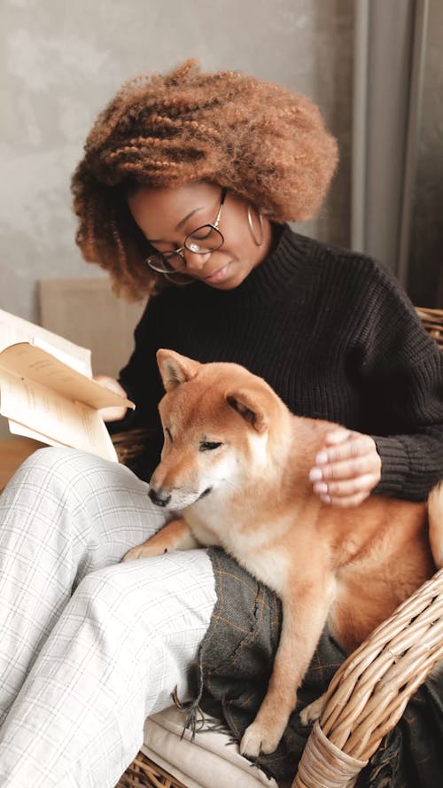 Woman Caressing Dog While Holds A Book