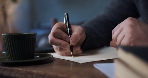 Elderly Man Writing on a Piece of Paper