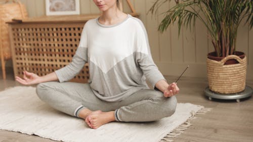 A Woman Meditating while Holding an Incense Stick