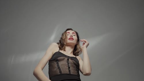 Low Angle Shot of a Woman with Red Lips and Eyebrows Dancing