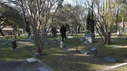 A Man Standing in Front of a Grave