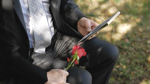 Close-Up Video of a Couple Holding Flowers and a Picture