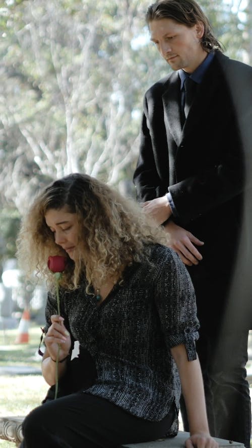 Man Comforting a Woman at the Cemetery