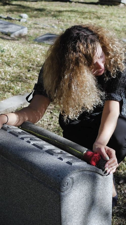 Woman Crying in Front of a Gravestone