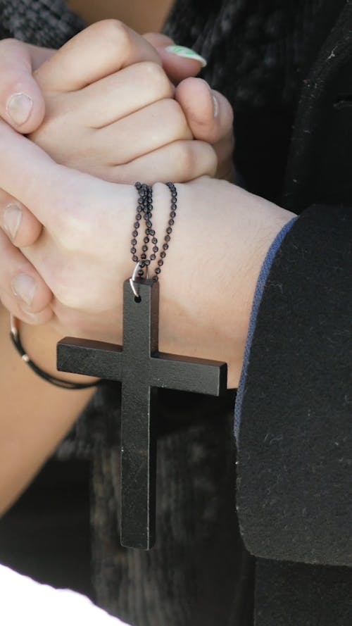 A Couple Holding Hands During the Funeral