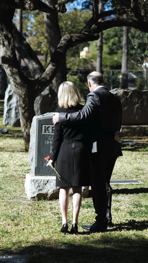 People Standing in Front of a Gravestone