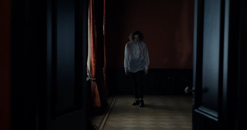 A Man Dancing in a Dimly Lit Hallway
