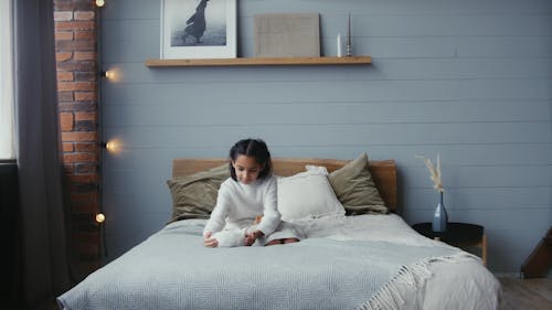 A Girl Holding a Rabbit in the Bed
