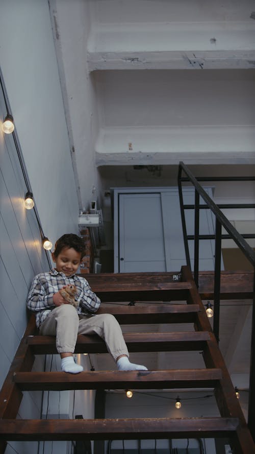 A Boy Petting a Rabbit in the Stairs