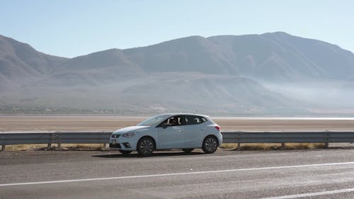 A Person Driving a White Car on the Road