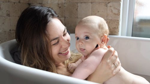 A Mother Kissing Her Baby while Taking a Bath