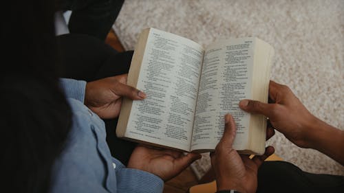 People Holding a Bible