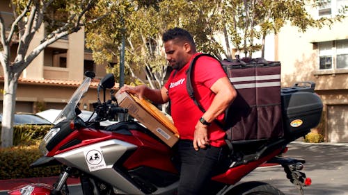 A Delivery Man Riding on His Motorbike