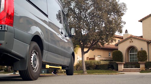 A Delivery Man Takes Out a Package from the Van