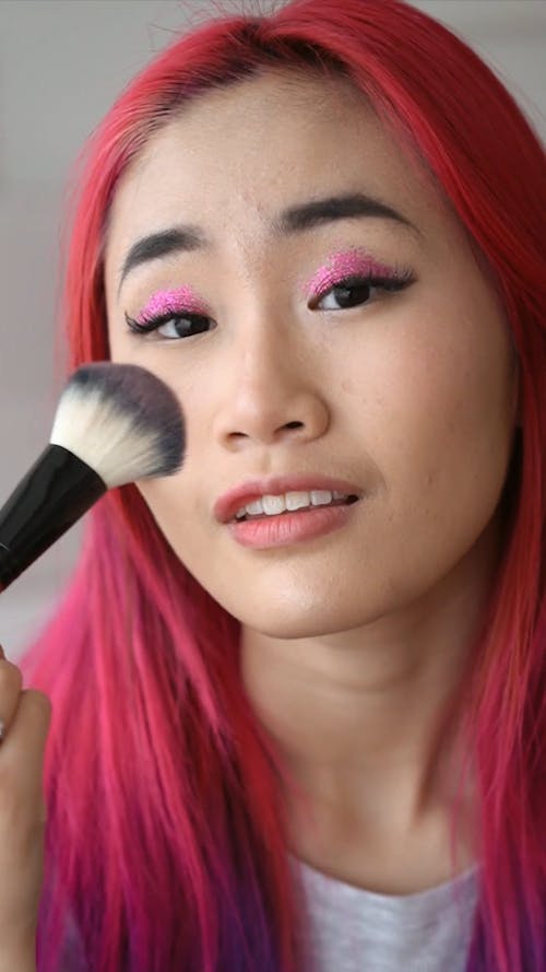 Close-Up View of Woman Applying Blush on her Face