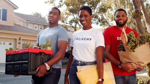Deliver Personnel Standing and Smiling While Holding Goods