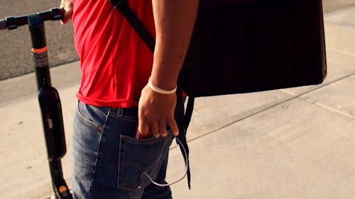 A Delivery Man Looking at His Smartphone 